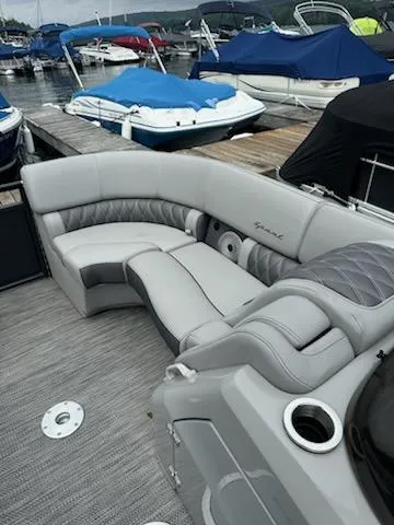Slide: The Image of 2022 Bennington QX 23 Quad Bench boat interior with luxurious seating at a marina. - 12