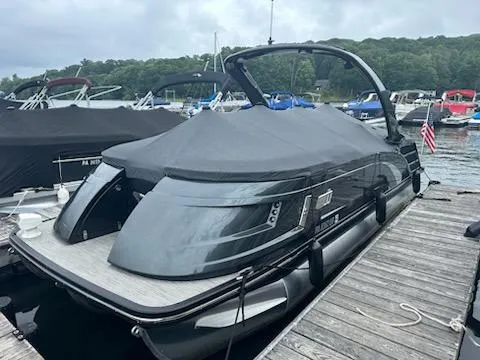 Slide: The Image of 2022 Bennington QX 23 Quad Bench pontoon boat docked with cover on. - 4