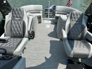 Slide: The Image of 2022 Bennington QX 23 Quad Bench interior with luxurious seating on a sunny day. - 5
