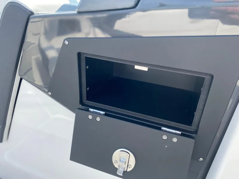 Slide: The Image of Open storage compartment on 2025 Monterey M-22 boat with secure latch. - 16
