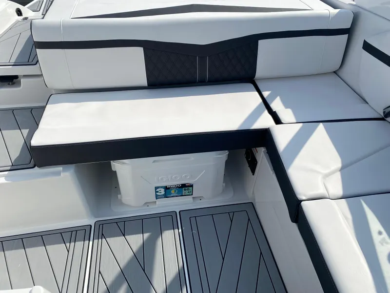 Slide: The Image of 2025 Monterey M-22 boat interior with white and black seating and integrated cooler. - 19