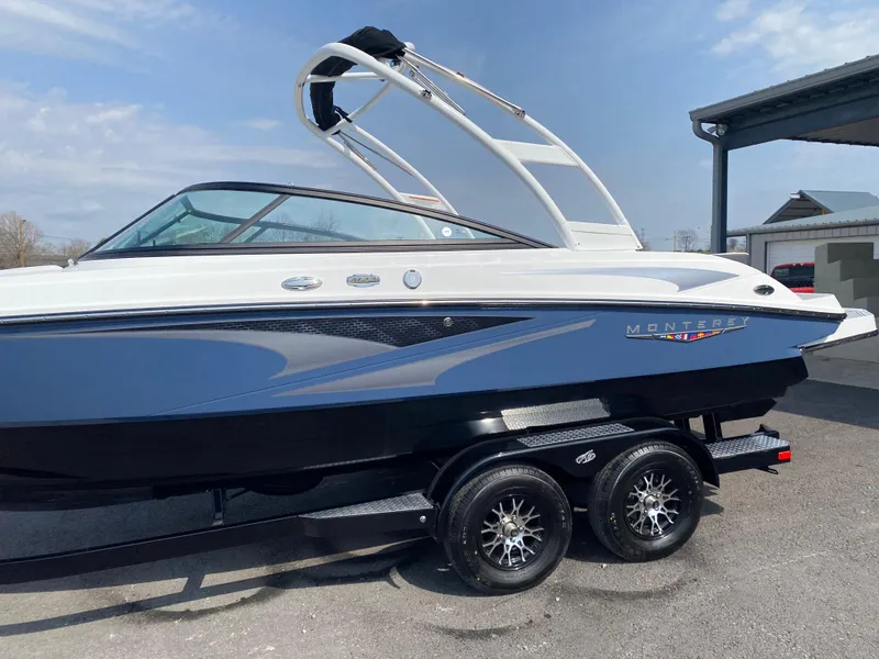 Slide: The Image of 2025 Monterey M-22 boat on trailer, blue and white design, parked outdoors. - 4