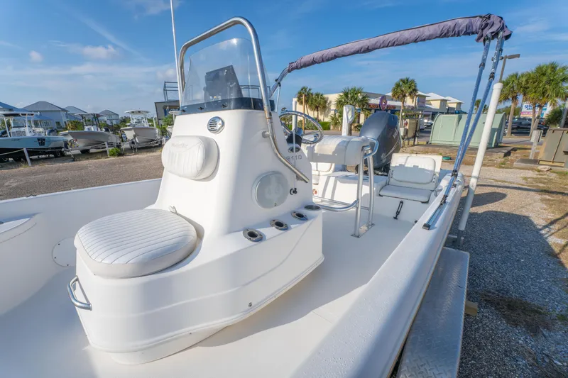 Slide: The Image of 2011 NauticStar 2110 Nautic Bay boat with seating, console, and canopy in a marina setting. - 13