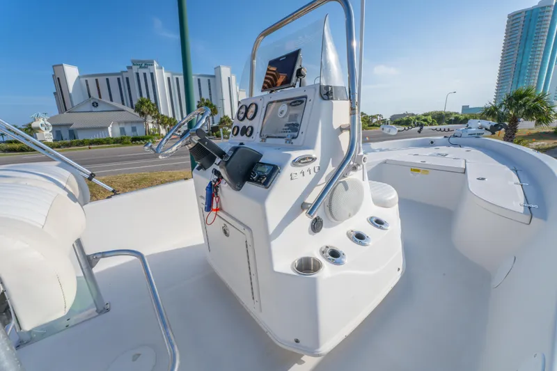 Slide: The Image of 2011 NauticStar 2110 Nautic Bay boat interior with control panel and seating, cityscape background. - 16