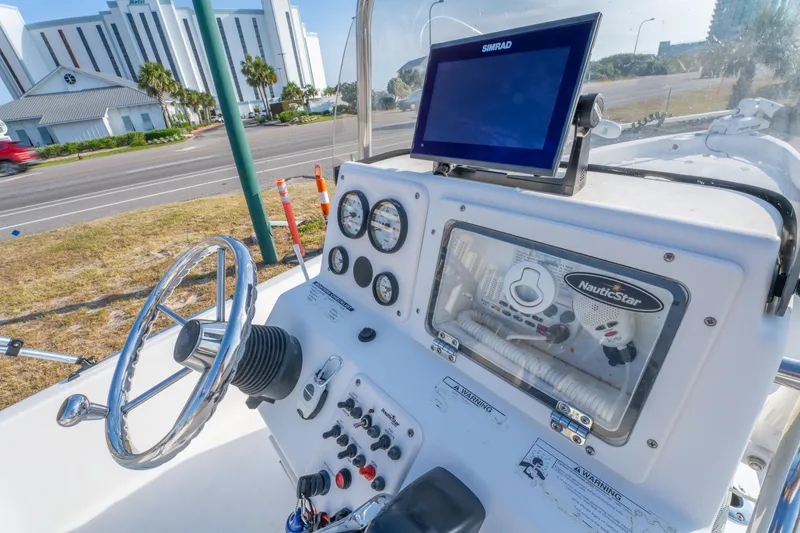 Slide: The Image of 2011 NauticStar 2110 Nautic Bay boat dashboard with steering wheel and navigation equipment. - 17