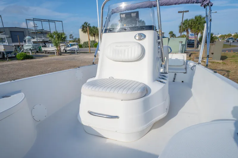 Slide: The Image of 2011 NauticStar 2110 Nautic Bay boat interior with white seating and console. - 21