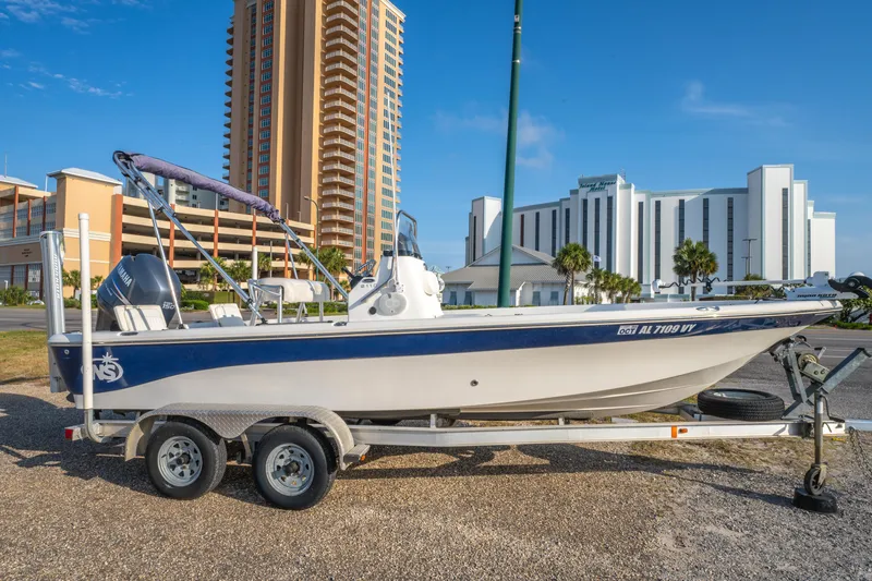 Slide: The Image of 2011 NauticStar 2110 Nautic Bay boat on trailer, urban background with tall buildings. - 3