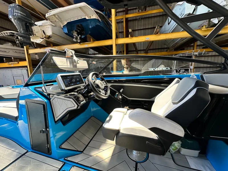 Slide: The Image of 2023 Yamaha Boats 255XD interior with modern dashboard and steering wheel in a vibrant blue finish. - 17