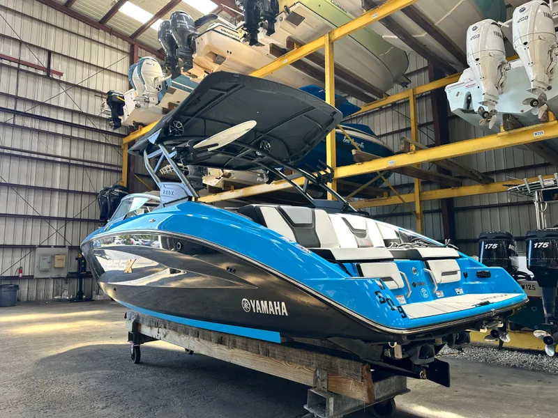 Slide: The Image of 2023 Yamaha Boats 255XD in a storage facility, showcasing sleek design and vibrant blue color. - 2