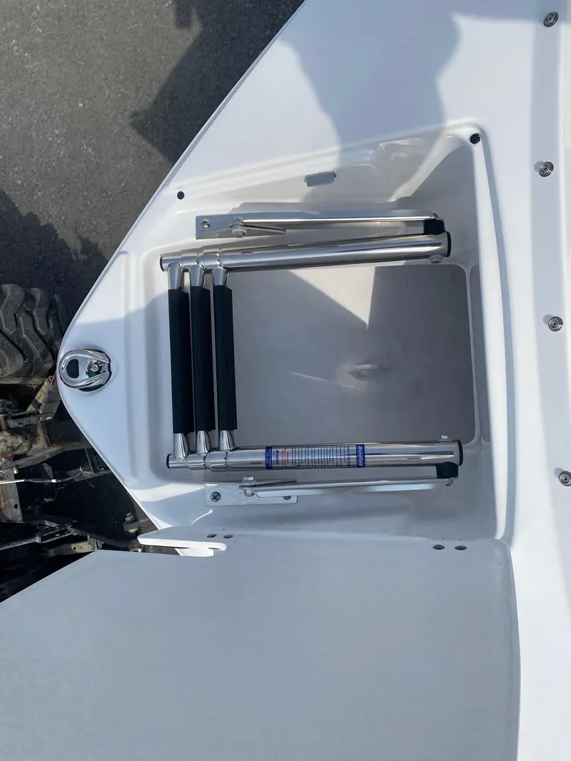 Slide: The Image of 2025 Monterey 224FS boat ladder compartment, open view, showing retractable ladder and latch mechanism. - 16