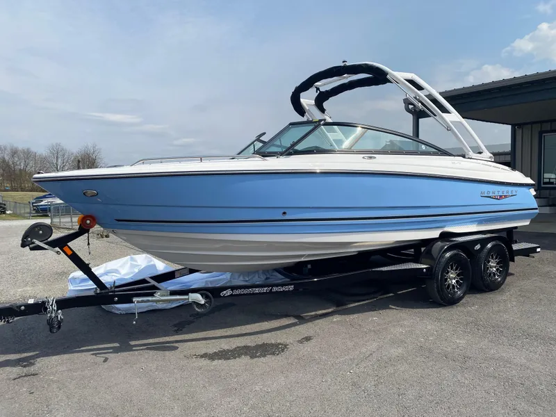 Slide: The Image of 2025 Monterey 224FS boat in light blue on a trailer, parked outdoors. - 2