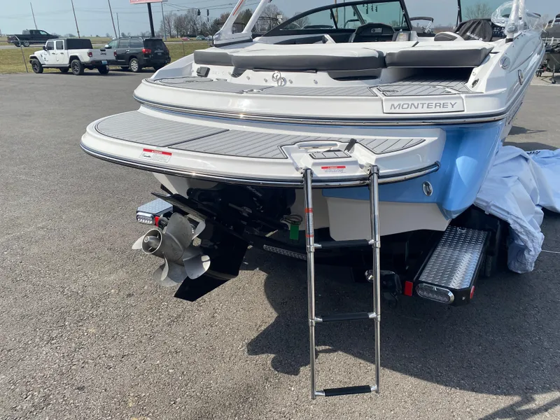 Slide: The Image of 2025 Monterey 224FS boat with swim platform and ladder, parked on asphalt. - 6
