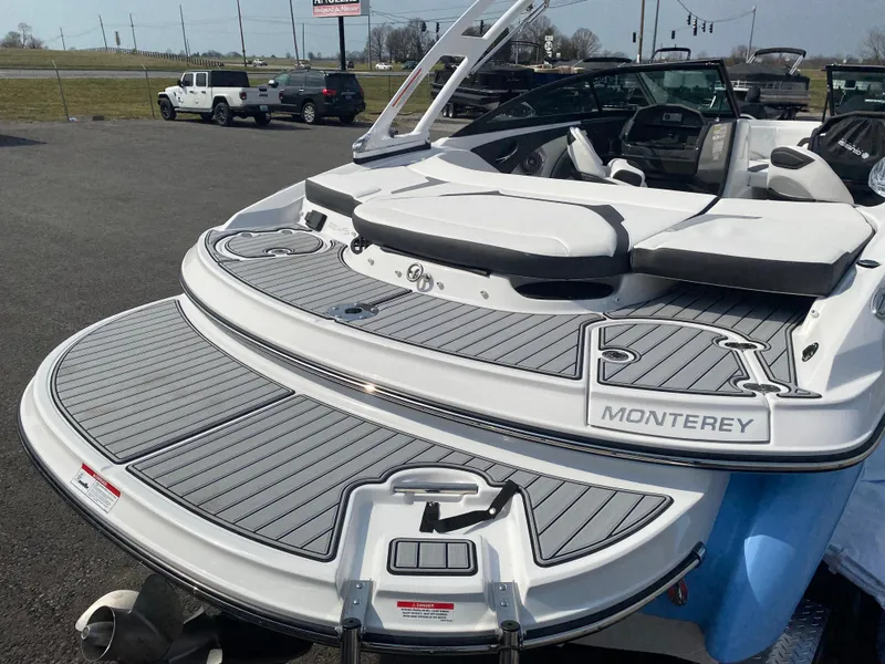 Slide: The Image of 2025 Monterey 224FS boat with sleek design and spacious deck, parked outdoors. - 7
