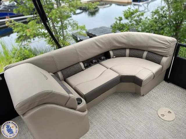 Slide: The Image of 2024 Bennington 23 LSRC boat interior with plush seating and cup holders, dockside view. - 7