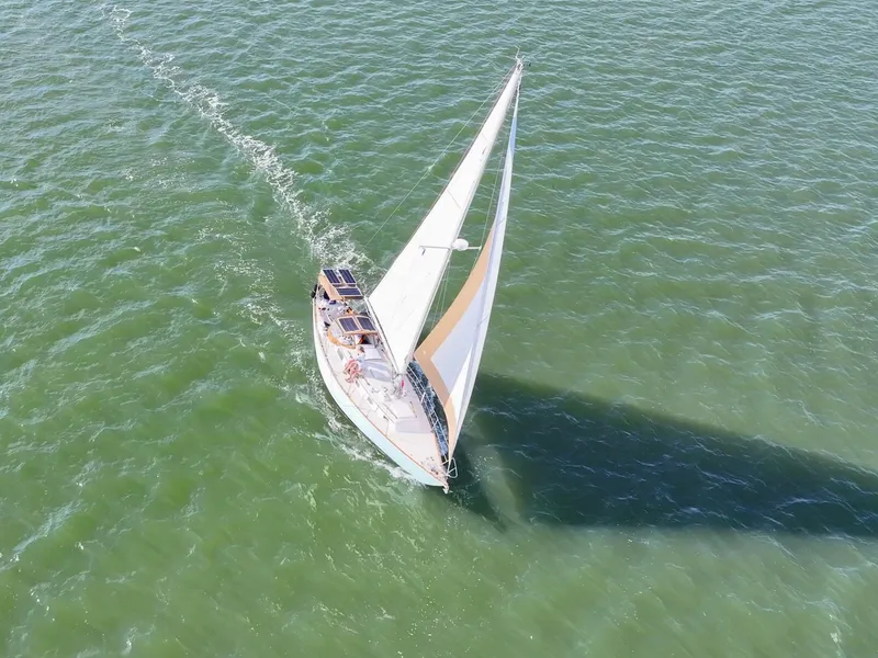 Slide: The Image of Aerial view of 1981 Bristol 40 sailboat navigating through green ocean waters. - 14