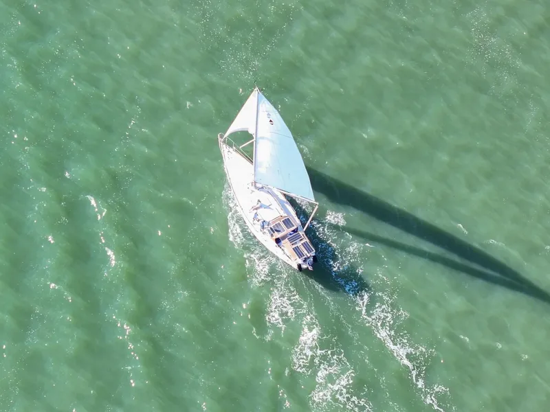 Slide: The Image of Aerial view of 1981 Bristol 40 sailboat navigating through green ocean waters. - 17