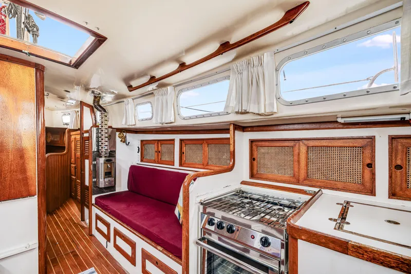 Slide: The Image of Interior of a 1981 Bristol 40 sailboat with wood accents and a compact kitchen. - 19