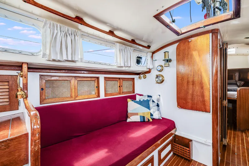 Slide: The Image of Interior of 1981 Bristol 40 sailboat with red seating, wooden accents, and nautical decor. - 20