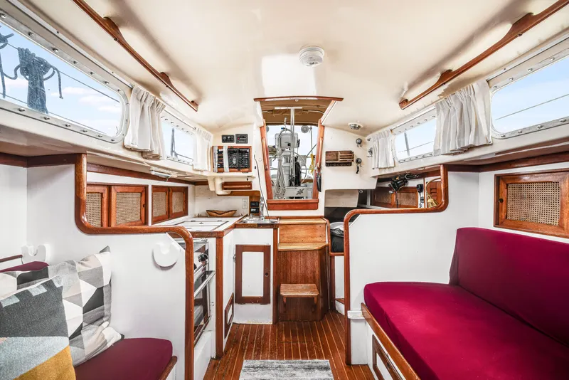 Slide: The Image of Interior of a 1981 Bristol 40 sailboat, featuring wood accents and cozy seating. - 21