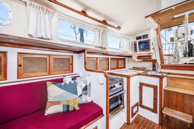 Slide: The Image of 1981 Bristol 40 yacht interior with wooden cabinetry, red seating, and nautical decor. - 23