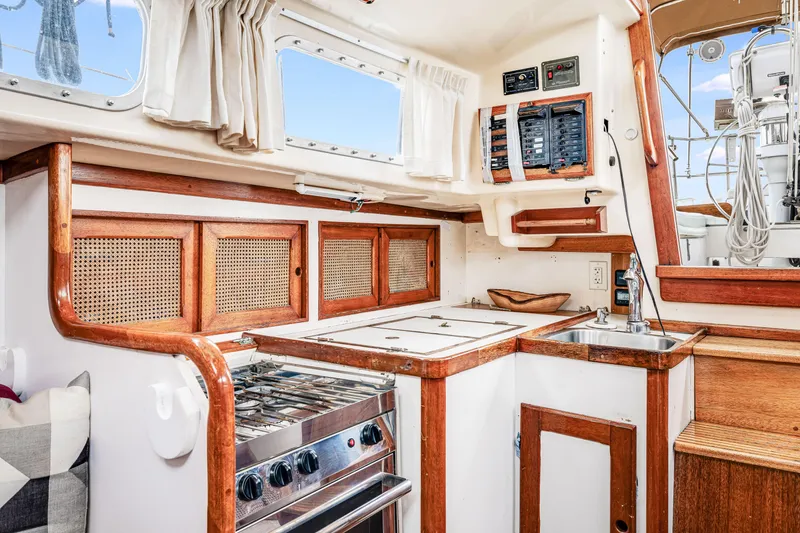 Slide: The Image of Interior of a 1981 Bristol 40 sailboat kitchen with wood accents and appliances. - 24