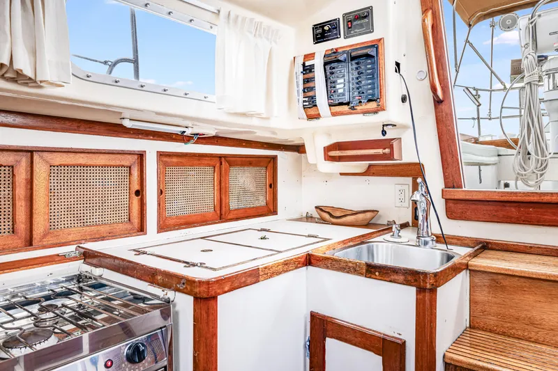 Slide: The Image of 1981 Bristol 40 yacht interior with wooden cabinetry, stove, and sink in the galley area. - 26