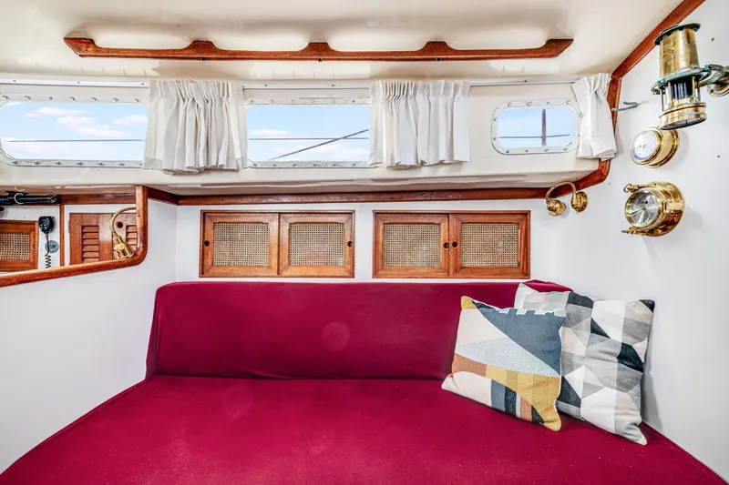 Slide: The Image of Interior of 1981 Bristol 40 sailboat with red seating and decorative pillows. - 31