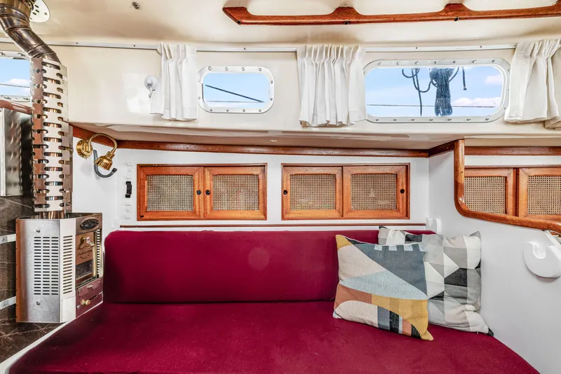 Slide: The Image of Interior of a 1981 Bristol 40 sailboat with red seating and wooden cabinets. - 32