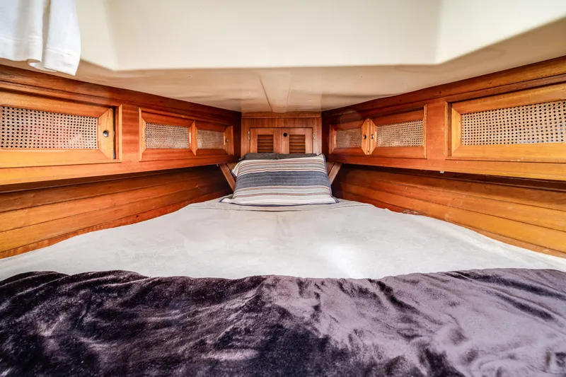 Slide: The Image of Cozy cabin interior of 1981 Bristol 40 sailboat with wooden paneling and bedding. - 34