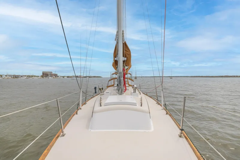 Slide: The Image of Sailing on a 1981 Bristol 40 yacht, calm waters, clear sky, and distant shoreline. - 36