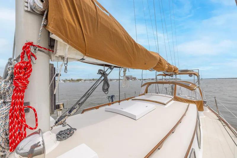 Slide: The Image of 1981 Bristol 40 sailboat deck with tan sail cover, docked on calm water under blue sky. - 37