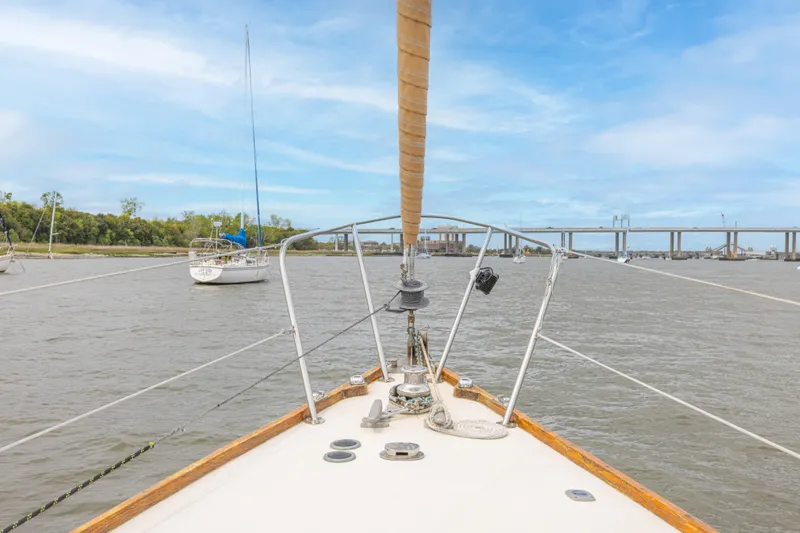 Slide: The Image of Bow view of 1981 Bristol 40 sailboat on a calm river with bridge in background. - 40
