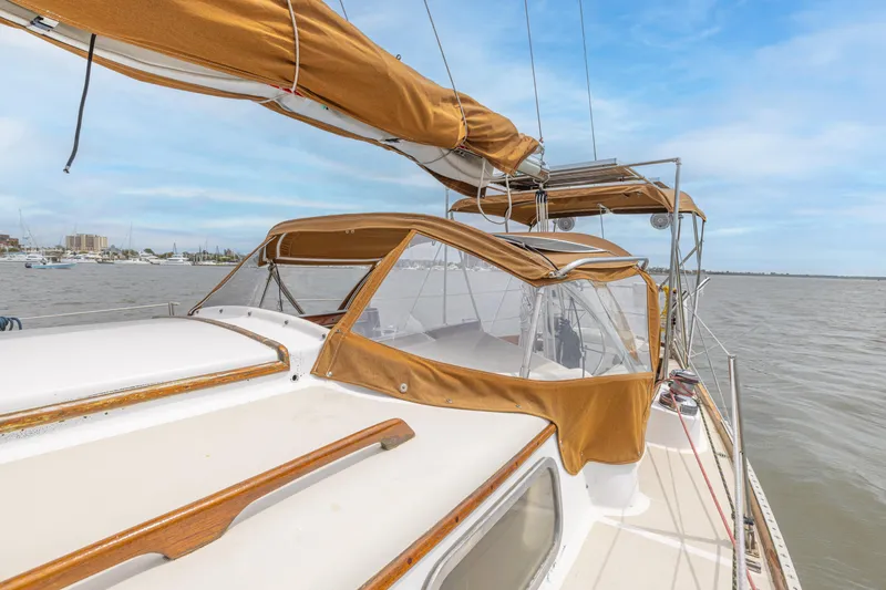 Slide: The Image of 1981 Bristol 40 sailboat with tan canvas covers on a calm sea. - 43