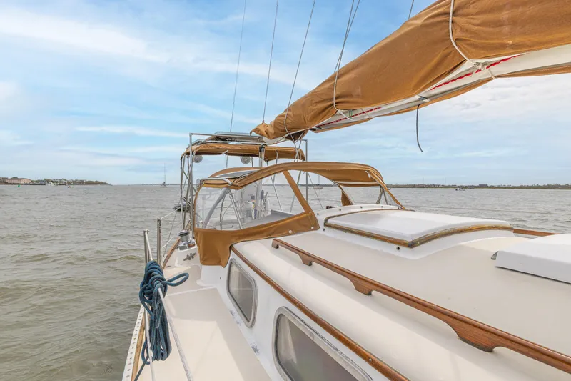 Slide: The Image of 1981 Bristol 40 sailboat on calm waters with tan sails and clear sky. - 46