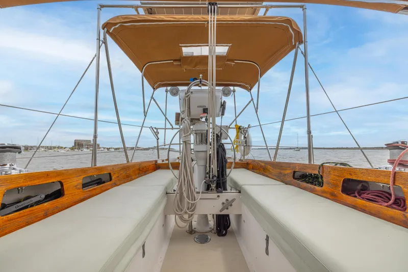 Slide: The Image of 1981 Bristol 40 sailboat cockpit with canopy, featuring wooden trim and nautical equipment. - 49