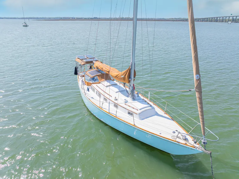 Slide: The Image of 1981 Bristol 40 sailboat on calm water, featuring a sleek design and tan sails. - 5