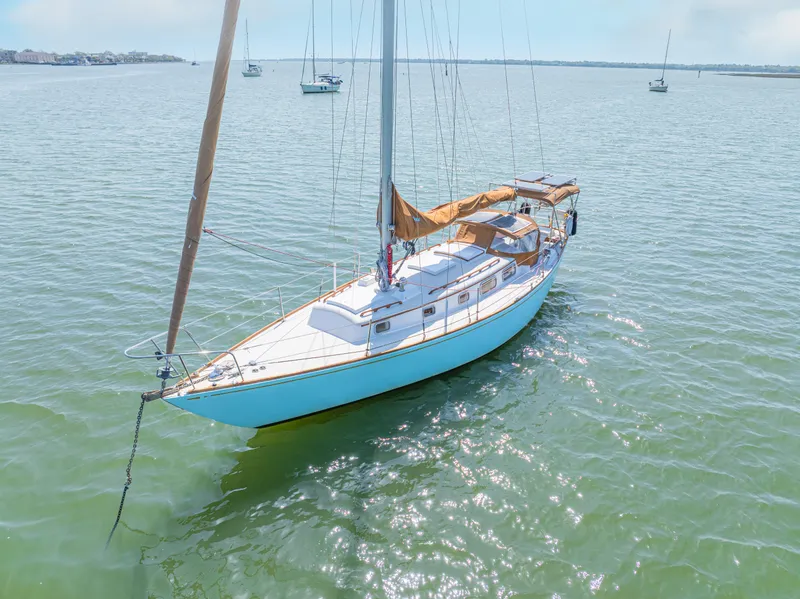 Slide: The Image of 1981 Bristol 40 sailboat anchored on calm water under clear skies. - 6