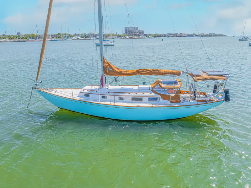 Slide: The Image of 1981 Bristol 40 sailboat on calm water, clear sky, marina in background. - 7