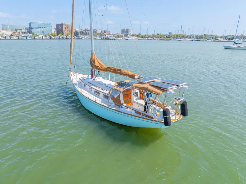 Slide: The Image of 1981 Bristol 40 sailboat on calm water with cityscape background. - 8