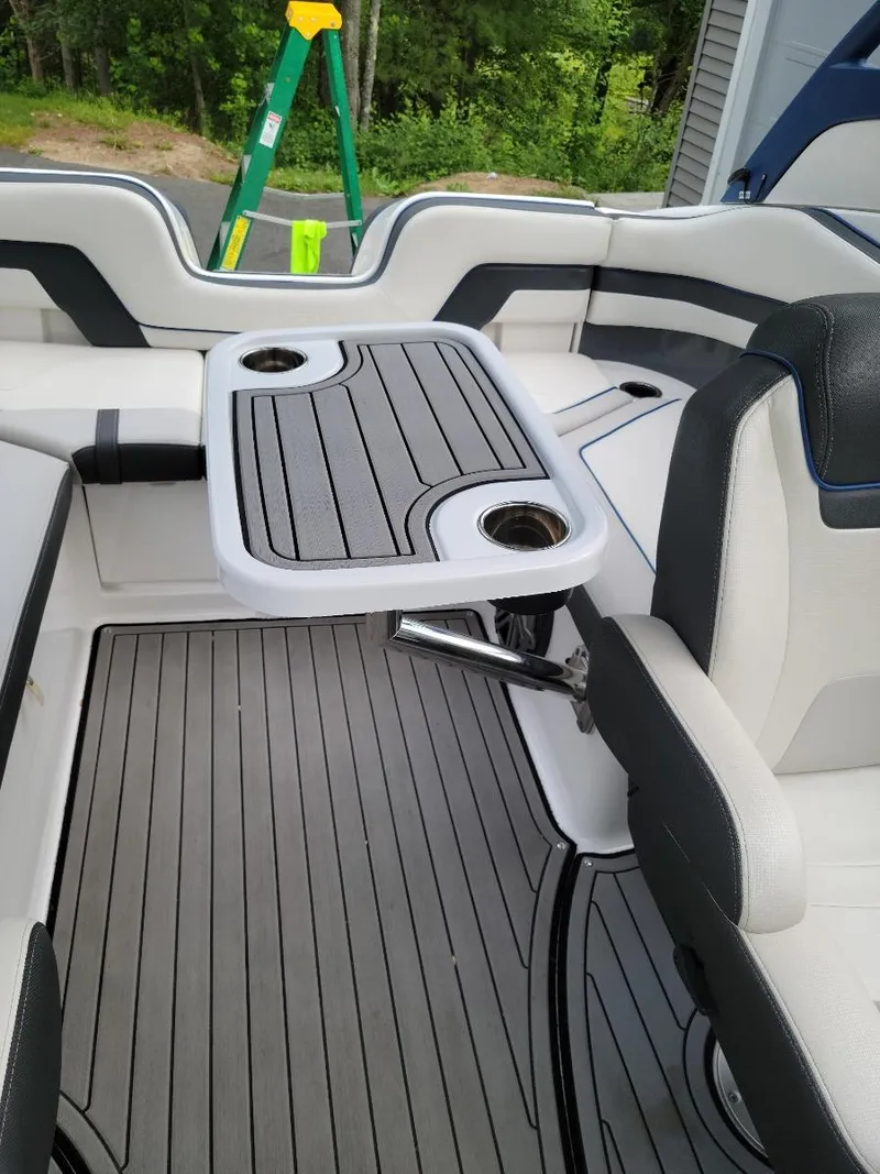 Slide: The Image of 2018 Yamaha Boats 242 Limited S interior with seating and table, featuring sleek design and cup holders. - 15