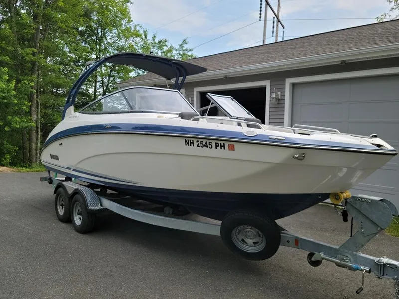 Slide: The Image of 2018 Yamaha Boats 242 Limited S on trailer, parked near garage. - 2