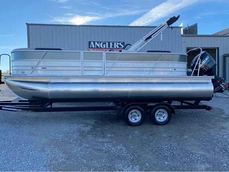 Slide: The Image of 2024 Berkshire LE Series 22RFX pontoon boat on trailer, parked outside Anglers Outpost. - 1