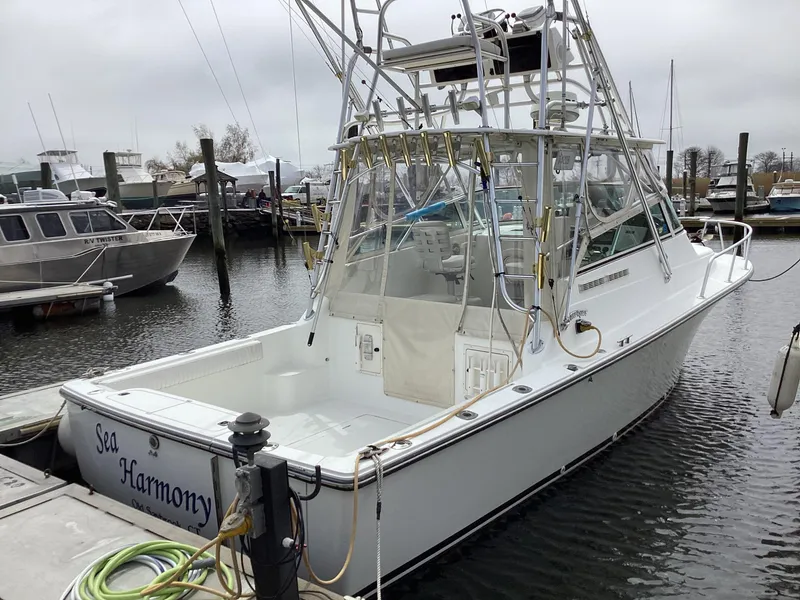 Slide: The Image of 2001 Henriques 28 Express boat named "Sea Harmony" docked at a marina. - 10