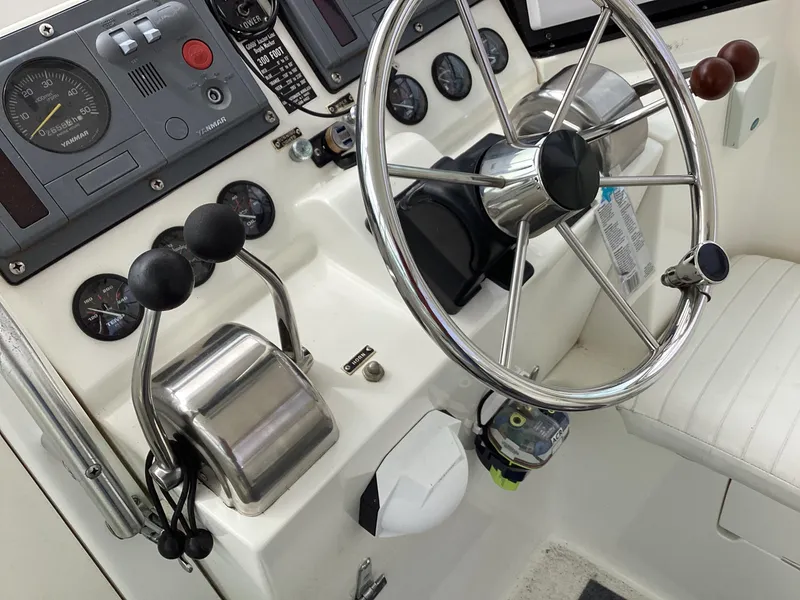 Slide: The Image of 2001 Henriques 28 Express boat helm with steering wheel and control panel. - 14