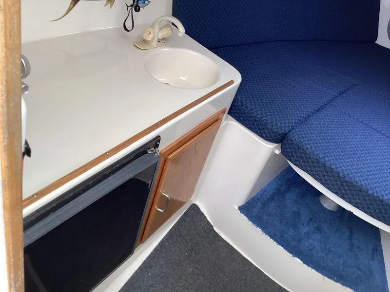 Slide: The Image of 2001 Henriques 28 Express cabin interior with sink, mini fridge, and blue seating. - 18