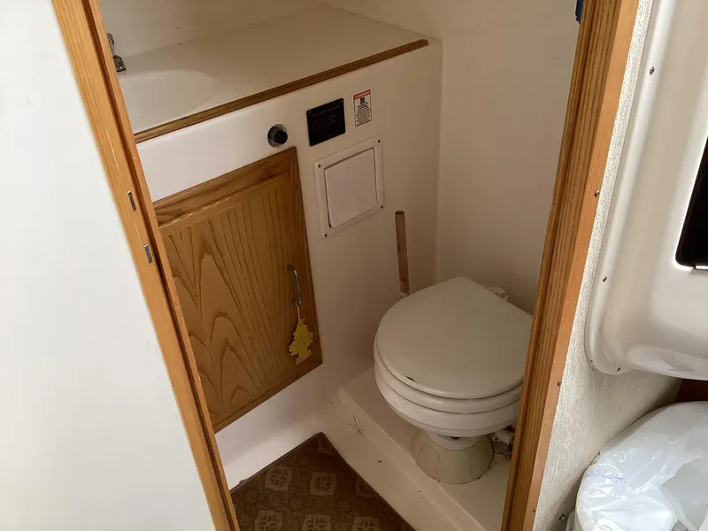 Slide: The Image of 2001 Henriques 28 Express boat bathroom with wooden cabinet and white toilet. - 24