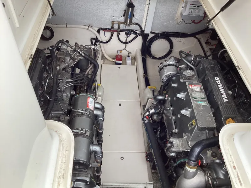 Slide: The Image of Engine compartment of a 2001 Henriques 28 Express boat, featuring dual Yanmar engines. - 32