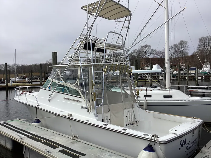 Slide: The Image of 2001 Henriques 28 Express boat docked at marina, featuring a tower and spacious deck. - 8