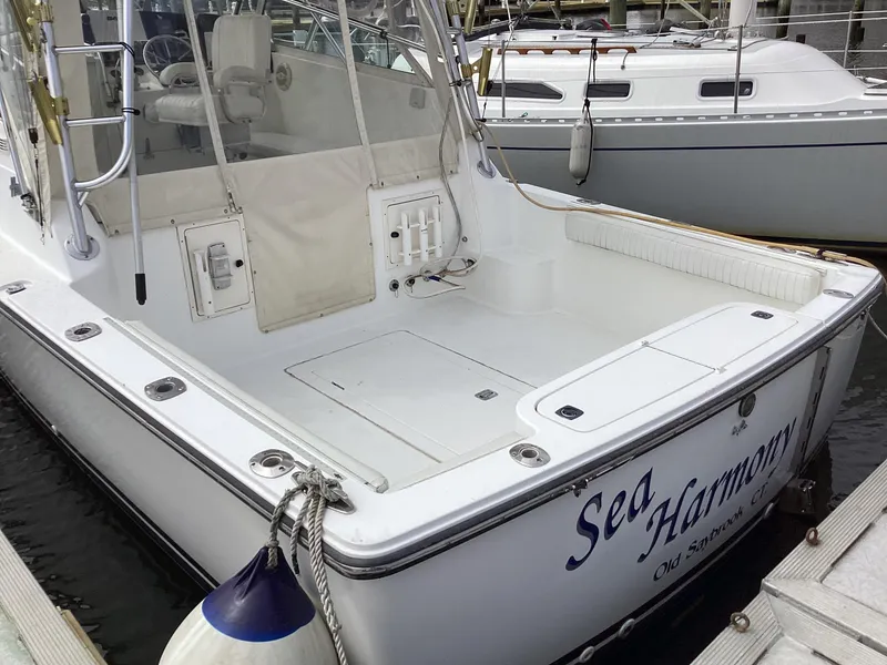 Slide: The Image of 2001 Henriques 28 Express boat docked, featuring spacious deck and "Sea Harmony" name. - 9