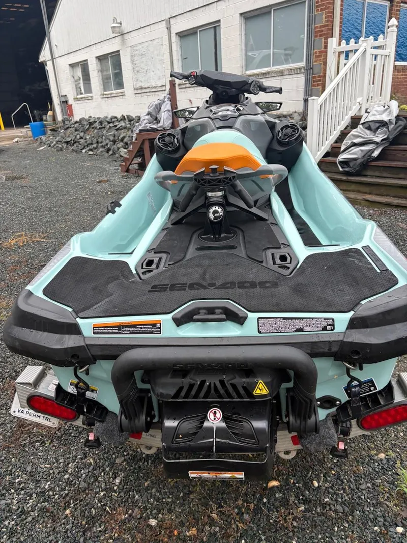 Slide: The Image of 2022 Sea-Doo Wake Pro 230 jet ski parked on gravel near a building. - 2